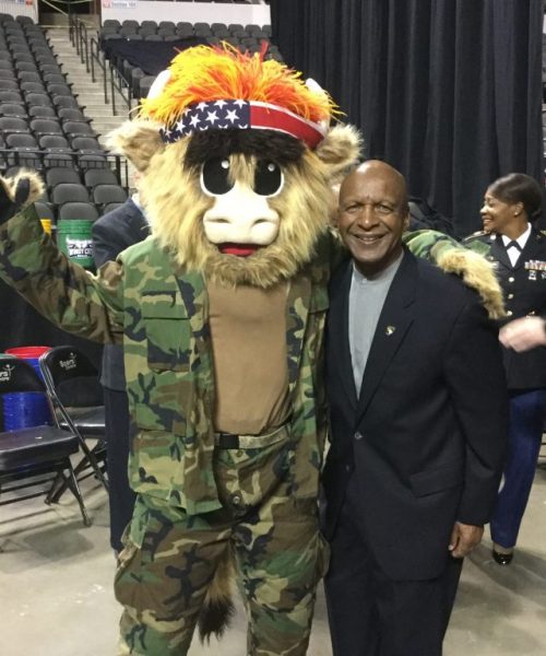 Image of Jesse White standing with mascot